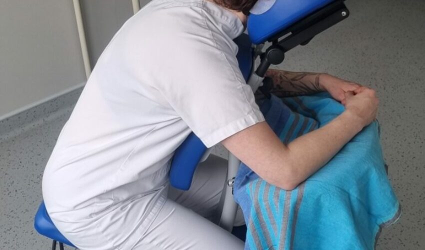 Soignant installé sur une chaise de massage assis